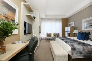 1 dormitorio con 1 cama grande, sofá y escritorio en 305 Sandton Skye, en Johannesburgo