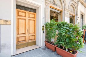 eine Tür eines Gebäudes mit Pflanzen davor in der Unterkunft Palazzo Medici Apartments in Florenz