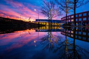 eine Reflexion von Bäumen in einem Wasserkörper bei Sonnenuntergang in der Unterkunft Hotel De Bonte Wever Assen in Assen