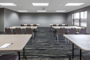uma sala de aula com mesas e cadeiras numa sala em AmericInn by Wyndham Iron Mountain em Iron Mountain