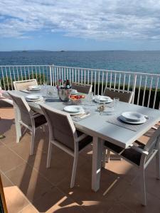 Una mesa blanca y sillas en un balcón con vista al mar. en Villa Nieves, en Ibiza