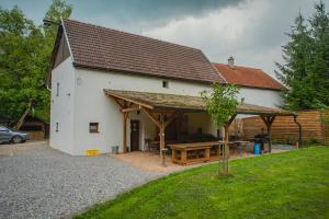 a white building with a picnic table in front of it at Farma Zelená Ruža in Kľačno