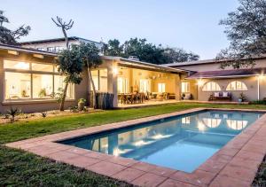 a house with a swimming pool in the yard at Ngoye Lodge in Mtunzini