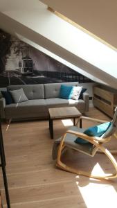 salon z kanapą i krzesłem w obiekcie Apartament Limanowskiego w Krakowie