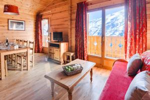 a living room with a couch and a table at travelski home select - Chalets Le Grand Panorama II 3 stars in Valmeinier