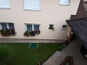 anterior view of a house with flowers in windows at IRIS Room & Apartment in Slunj
