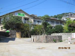 a building with a sign on the side of it at Ryokan Mikasaya in Beppu