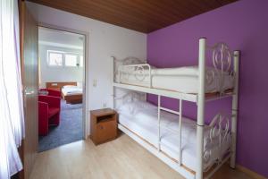 ビュルサーベルクにあるHotel Garni Brigitteの紫の壁のベッドルーム1室(二段ベッド2組付)