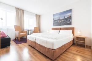 1 dormitorio con 1 cama grande y 1 mesa en Flatista Boutique Hotel - Self Check-in en Múnich