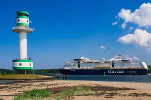 a cruise ship is docked next to a lighthouse at Haus Pries in Kiel