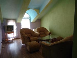 a living room with two chairs and a table and a tv at Dionis Hotel in Petrich