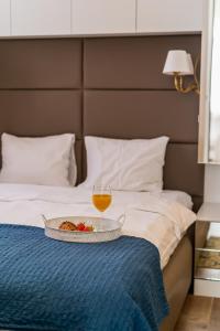 ein Tablett mit Essen und ein Glas Wein auf dem Bett in der Unterkunft AH Design Luxury Apartments in Opatija