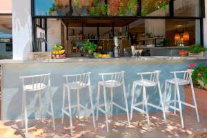 a row of white stools at a bar at Hotel Acapulco in Lloret de Mar