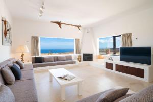 a living room with a couch and a tv at Villa Agave // Villa Cardón in Puerto Calero