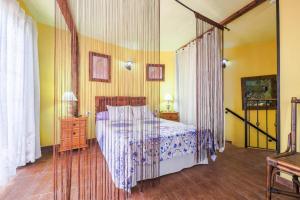 ein Schlafzimmer mit einem Himmelbett und gelben Wänden in der Unterkunft Casa Carmela in La Guancha