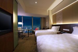 a hotel room with two beds and a flat screen tv at Osaka Marriott Miyako Hotel in Osaka