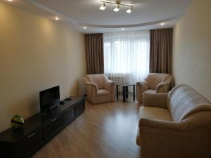 a living room with a couch and two chairs and a television at Big Apartment in Rivne center in Rivne