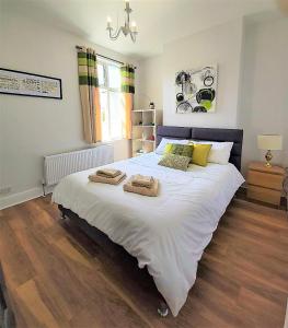a bedroom with a large bed with two towels on it at Beautifully renovated 2 Bed flat - Close to beach in Southend-on-Sea