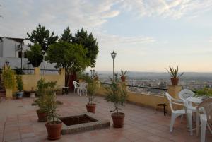 a patio with tables and chairs and a view of a city at Carmen en el Albaicín con Jardin y Vistas in Granada