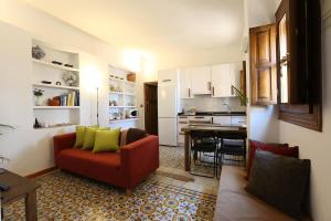 a living room with a red couch and a kitchen at Carmen en el Albaicín con Jardin y Vistas in Granada