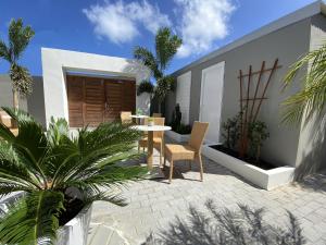 a patio with a table and chairs and palm trees at Sunshine SXM Studios in Grand Case