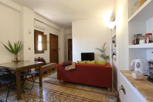 een woonkamer met een rode bank en een tafel bij Carmen en el Albaicín con Jardin y Vistas in Granada