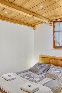1 dormitorio con 1 cama con toallas en Appartement privatif type chalet cosy et calme, en Métabief