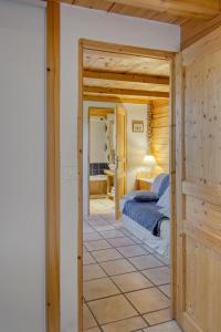 a bedroom with a bed and a door leading into a room at Appartement privatif type chalet cosy et calme in Métabief