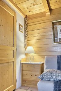 a bedroom with a bed and a desk with a lamp at Appartement privatif type chalet cosy et calme in Métabief