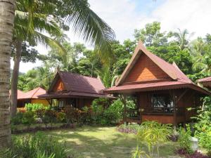 une rangée de cottages dans un complexe avec des palmiers dans l'établissement Le Dugong Libong Resort, à Ko Libong