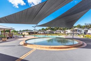 a swimming pool with a large fountain in front of it at Beachfront by Gateway Lifestyle Holiday Parks in Hallidays Point