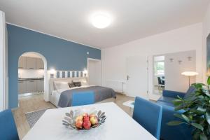 a hotel room with a bed and a table with a bowl of fruit at Villa Bella Vista - Apartment Blue in Pörtschach am Wörthersee