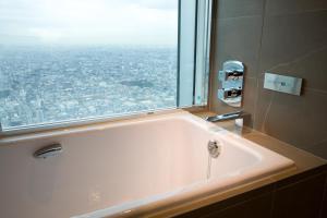 a bath tub in a bathroom with a large window at Osaka Marriott Miyako Hotel in Osaka