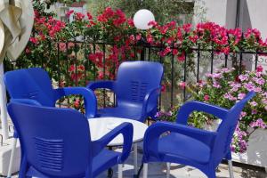 eine Terrasse mit blauen Stühlen und rosa Blumen in der Unterkunft Villa Kela in Ksamil