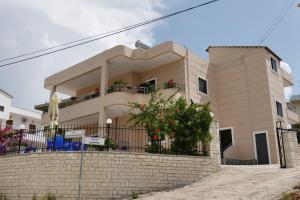 una gran casa blanca con una pared de ladrillo en Villa Kela, en Ksamil