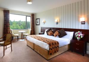 a hotel room with a large bed and a large window at Kiltimagh Park Hotel in Kiltimagh