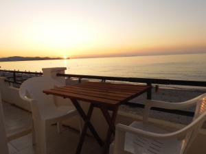 stół i krzesła na balkonie z widokiem na zachód słońca w obiekcie Abraham Apartments w Acharavi