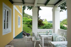 eine Terrasse mit einem Tisch, Stühlen und einem Fenster in der Unterkunft Villa Bella Vista - Apartment Blue in Pörtschach am Wörthersee