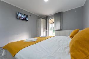 Un dormitorio con una cama grande con una manta amarilla. en Rtanjska bajka, en Boljevac