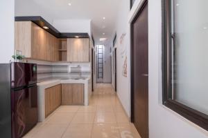 un pasillo que conduce a una cocina con armarios de madera en OYO Life 3246 Walnut Inn G-10, en Telukjambe
