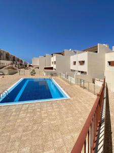 ein Schwimmbad vor einem Gebäude in der Unterkunft Los Cristianos 4 Bed Townhouse in Los Cristianos