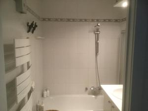 un bagno bianco con vasca e lavandino di Apartment Casino a Nieuwpoort