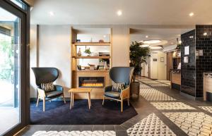 a lobby with two chairs and a fireplace at Point A Hotel London Paddington in London