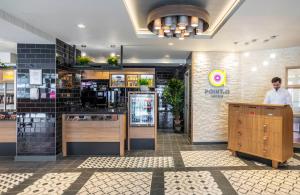 a man standing at a counter in a restaurant at Point A Hotel London Paddington in London