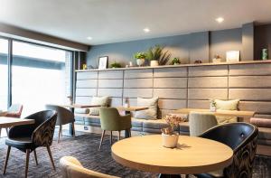 a restaurant with tables and chairs in a room at Point A Hotel London Paddington in London