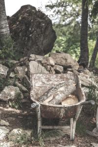 a stone bench in front of a pile of rocks at Sfendamos Wood Village in Agios Pavlos
