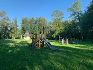 um parque infantil com um escorrega na relva em Blankenfeldes muiža em Tervete