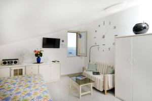 a white living room with a couch and a table at Mamma Rosanna 2 - Studio flat in Amalfi with terrace in Amalfi