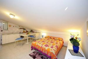 a bedroom with a bed and a desk and a kitchen at Mamma Rosanna 2 - Studio flat in Amalfi with terrace in Amalfi