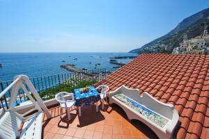a balcony with a table and chairs on a roof at Mamma Rosanna 2 - Studio flat in Amalfi with terrace in Amalfi